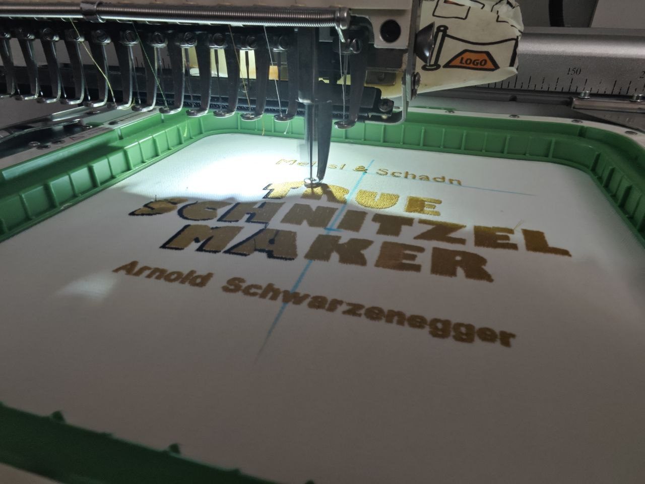 Stickmaschine in Aktion, Arnold Schwarzenegger Schürze bestickt
