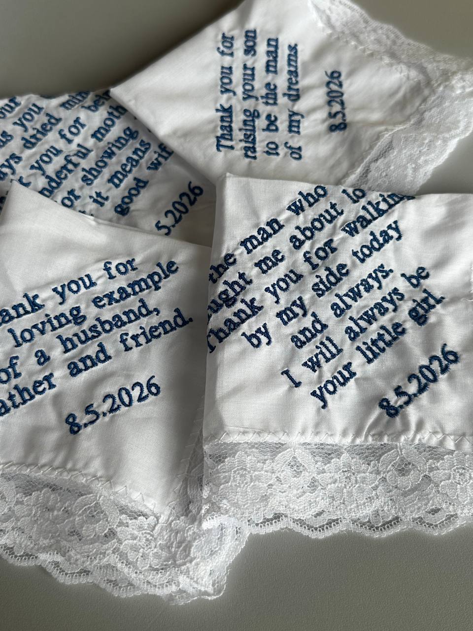 Hochzeitstaschentücher besticken in Wien: weiße Spitzentaschentücher mit individuellem Text in blauer Stickerei