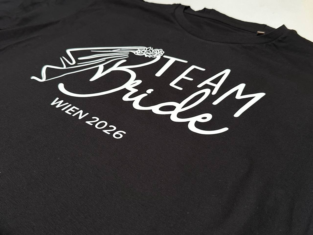 T-Shirt bedrucken in Wien: schwarzes Shirt mit weißem Team Bride Druck Wien 2026 für den Junggesellinnenabschied